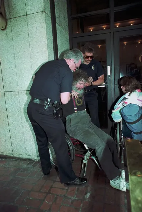 Framed Print : Wheelchair Bound Protester Blocking Building Entrance