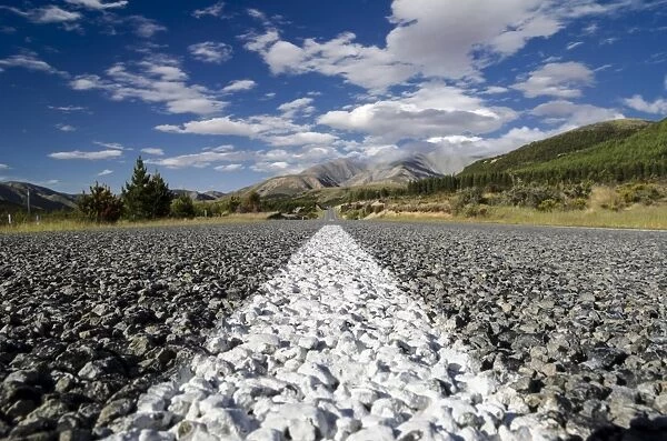 White road markings on a road with coarse asphalt, worms eye view, Arthurs Pass Road, South Island, New Zealand, Oceania