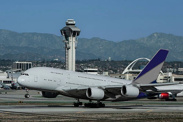 Wide body airliner taking off at Los Angeles International Airport (LAX) with control tower in background