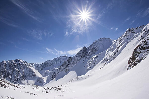 Winter landscape with sun toward the Steintalspitze summit, Stubai Alps, Tyrol, Austria
