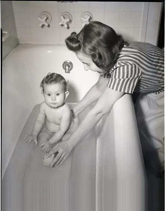 Framed Print : Woman Bathing Infant in Tub Framed Print : Woman Bathing Infant in Tub