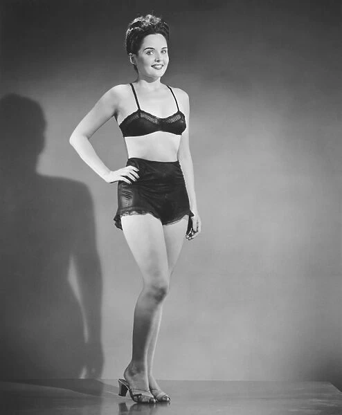 Woman in black underwear posing in studio, (B&W), portrait