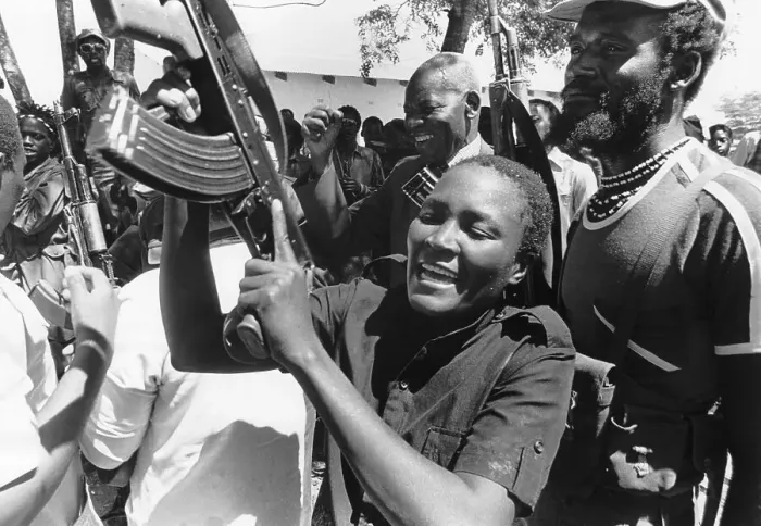 Framed Print : Woman Brandishes Rifle Before Crowd Framed Print : Woman Brandishes Rifle Before Crowd