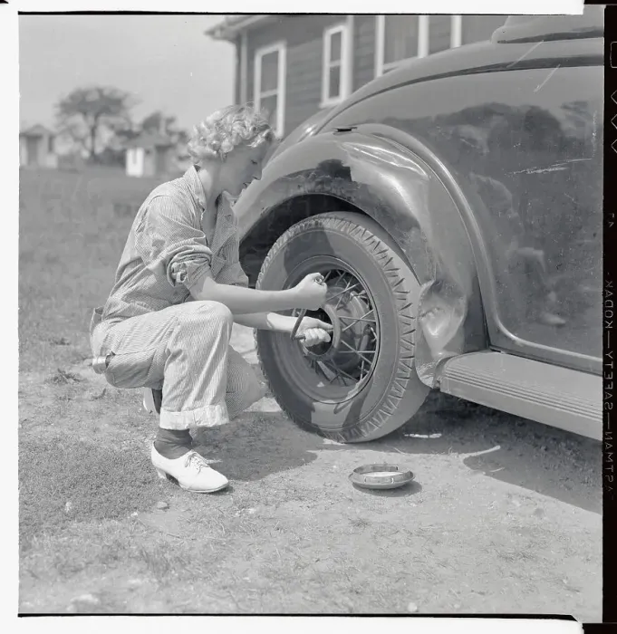 Framed Print : Woman Changing Tire at Gas Station Framed Print : Woman Changing Tire at Gas Station