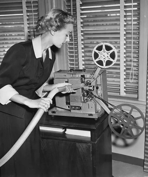 Framed Print : Woman Cleaning Film Projector with Vacuum Framed Print : Woman Cleaning Film Projector with Vacuum