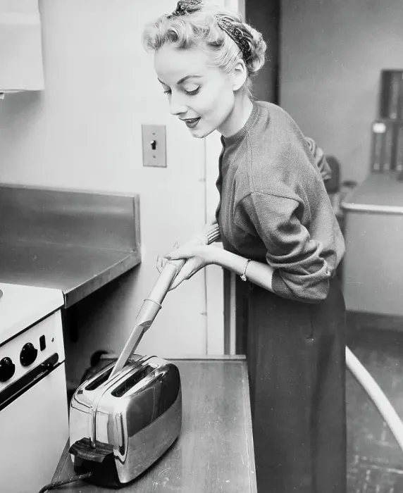 Framed Print : Woman Cleaning Toaster with Vacuum Cleaner Framed Print : Woman Cleaning Toaster with Vacuum Cleaner