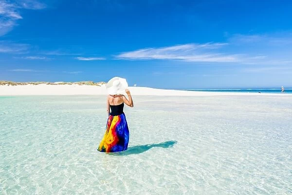 Woman with colorful dress standing on the turquoise water. Western Australia