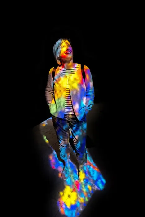 Framed Print : Woman in the colourful light of a stained glass window