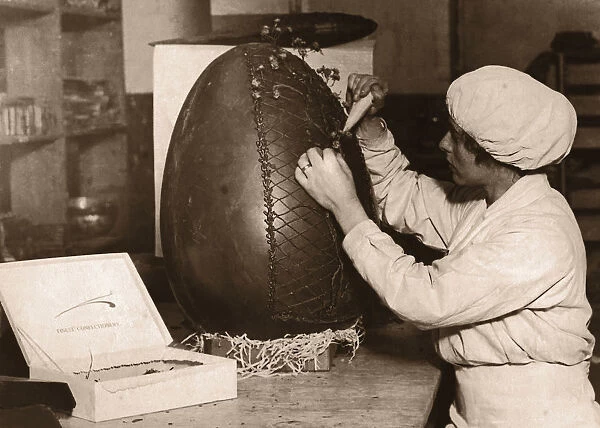 Woman Decorating Fifteen Pound Chocolate Easter egg (B&W sepia)