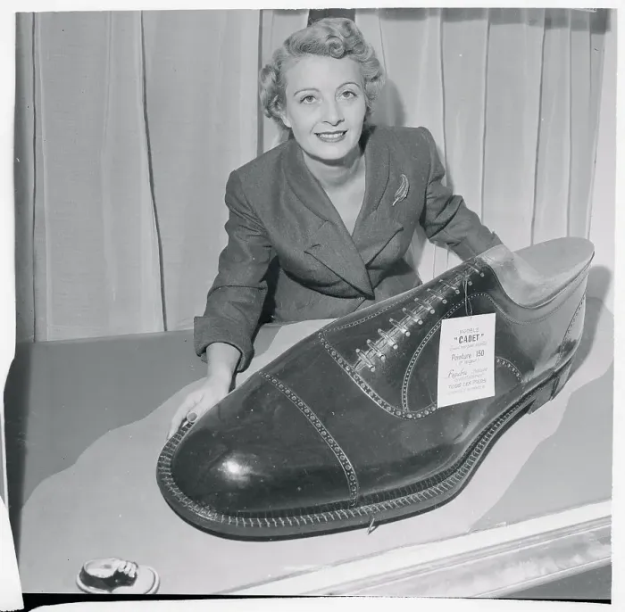 Framed Print : Woman Displaying Oversized Novelty Shoe Framed Print : Woman Displaying Oversized Novelty Shoe