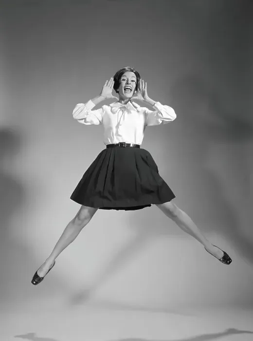 Framed Print : Woman doing cheerleader jump, hand up to mouth, yelling and screaming Framed Print : Woman doing cheerleader jump, hand up to mouth, yelling and screaming