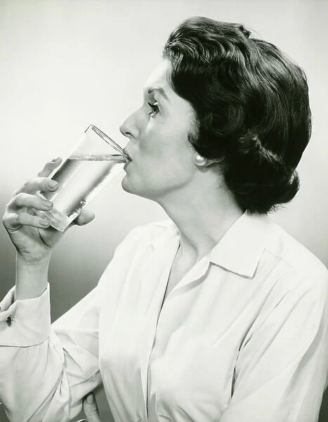 Woman drinking water, posing in studio, (B&W), (Portrait)