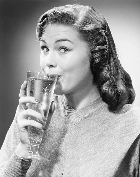 Woman drinking water is studio, (B&W)