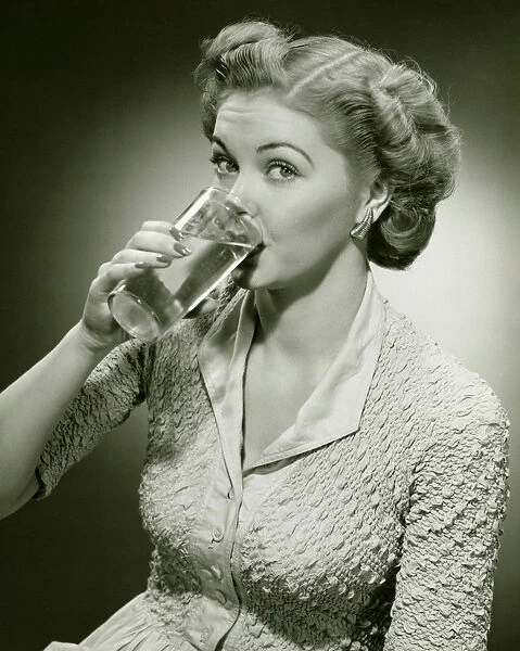Woman drinking water from tall glass, (B&W), (Close-up), (Portrait)