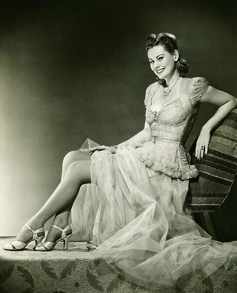 Woman in evening gown posing in studio, (B&W), portrait
