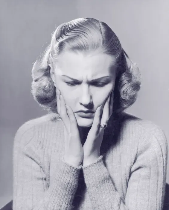 Framed Print : Woman frowning, holding hands to face (B&W) Framed Print : Woman frowning, holding hands to face (B&W)