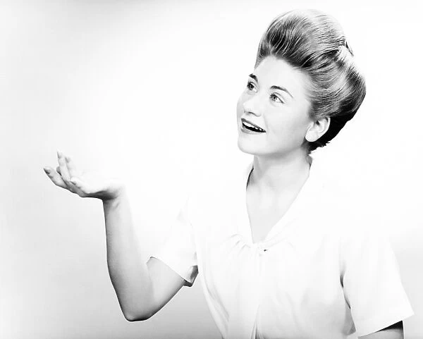 Woman gesturing in studio, (B&W), portrait