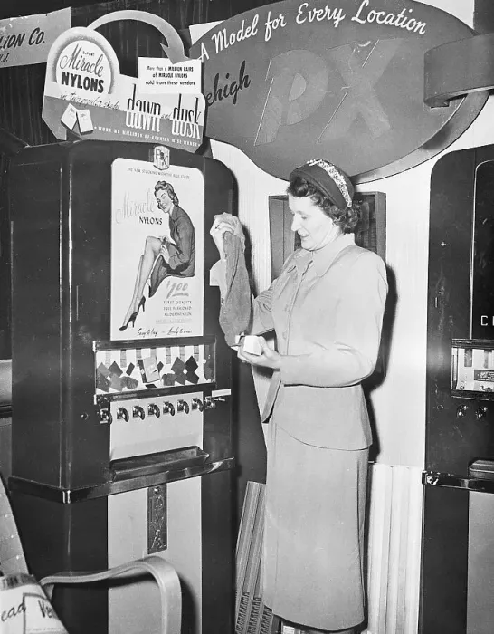 Framed Print : Woman Getting Stockings From Machine Framed Print : Woman Getting Stockings From Machine
