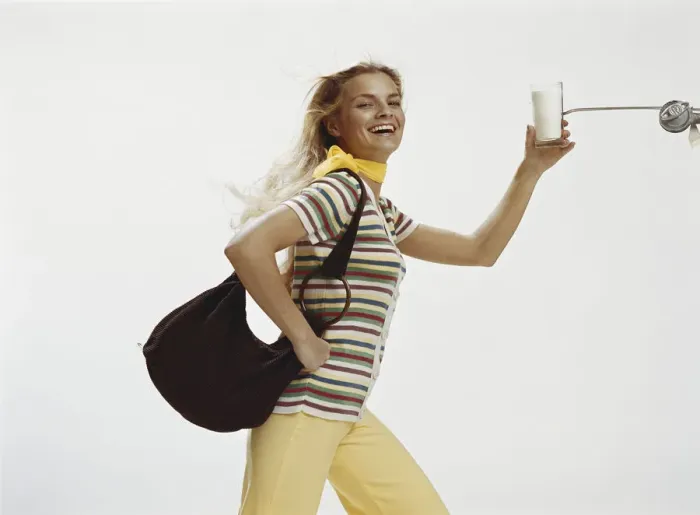 Framed Print : Woman with handbag holding glass of milk, close-up Framed Print : Woman with handbag holding glass of milk, close-up