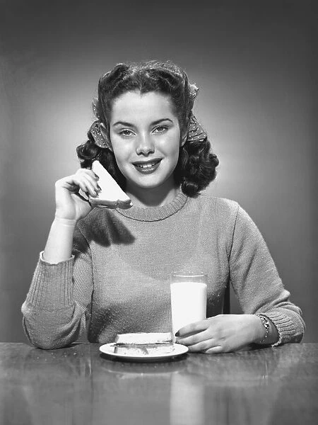 Woman having sandwich and milk, (B&W), portrait