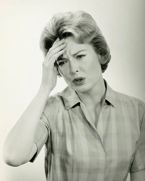Woman with headache, posing in studio, (B&W) (Portrait)
