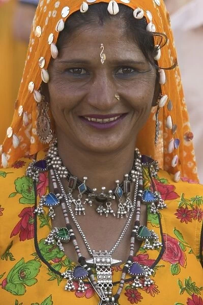 Woman in headscarf and jewelry smiling, close-up, portrait
