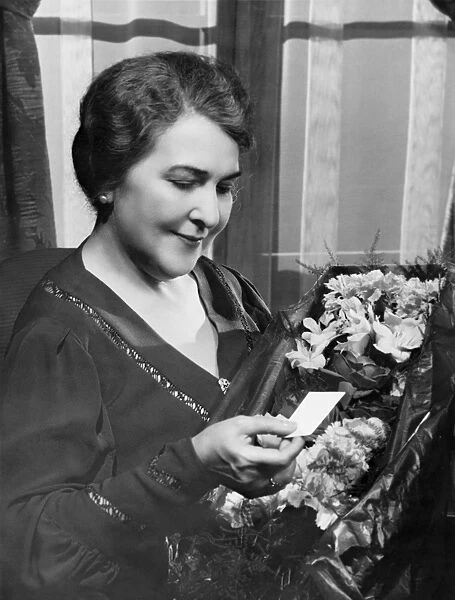 Woman holding bouquet, reading note, (B&W)