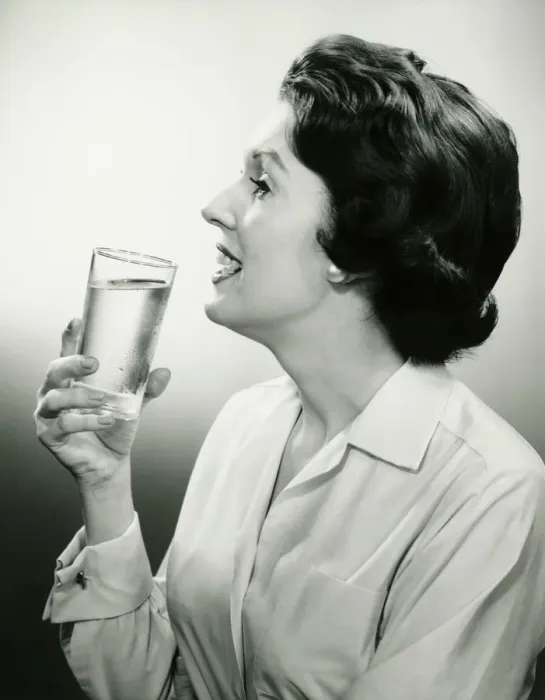 Framed Print : Woman holding glass of water, posing in studio, (B&W), (Portrait) Framed Print : Woman holding glass of water, posing in studio, (B&W), (Portrait)