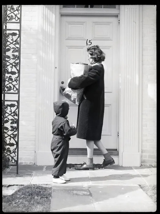 Framed Print : Woman Holding Groceries and Child Enter House Framed Print : Woman Holding Groceries and Child Enter House