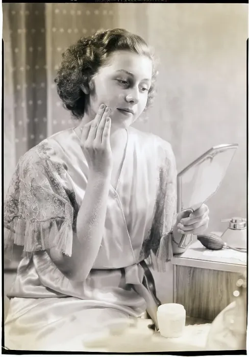 Framed Print : Woman Holding Mirror and Applying Cream Framed Print : Woman Holding Mirror and Applying Cream