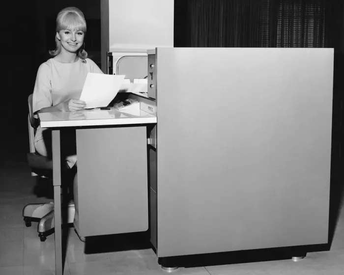 Framed Print : Woman holding paper and sitting at desk Framed Print : Woman holding paper and sitting at desk