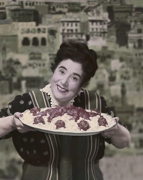 Woman holding prepared fettuccine with meatballs