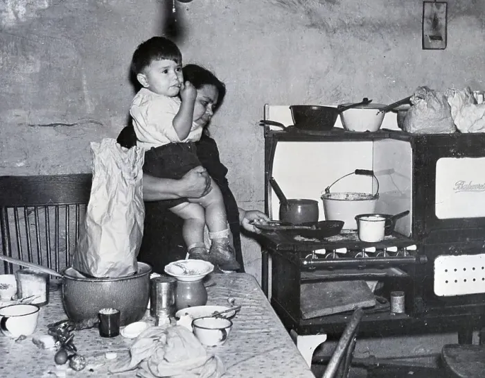 Framed Print : Woman Holds Child While Cooking;Poverty Framed Print : Woman Holds Child While Cooking;Poverty