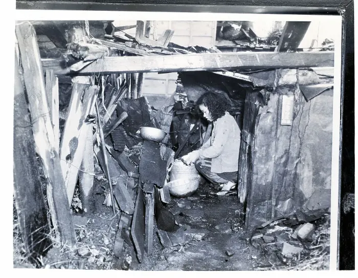Framed Print : Woman Kneels In Her Ramshackle Shelter Framed Print : Woman Kneels In Her Ramshackle Shelter