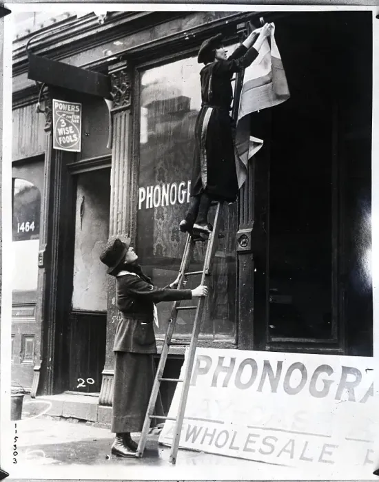 Framed Print : Woman on Ladder Fixes Women's Party Sign Framed Print : Woman on Ladder Fixes Women's Party Sign