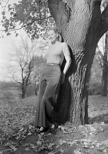 Woman leaning against tree, portrait