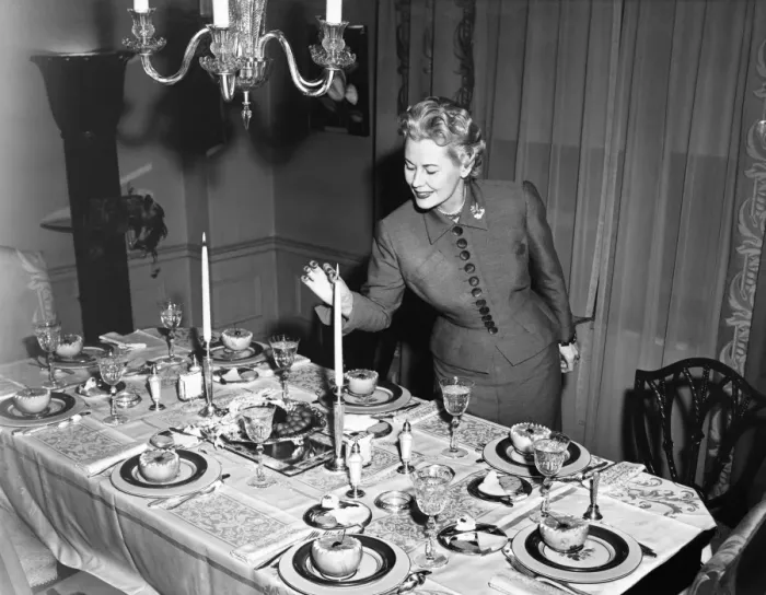 Framed Print : Woman lighting up candle, table ready for dessert, (B&W) Framed Print : Woman lighting up candle, table ready for dessert, (B&W)