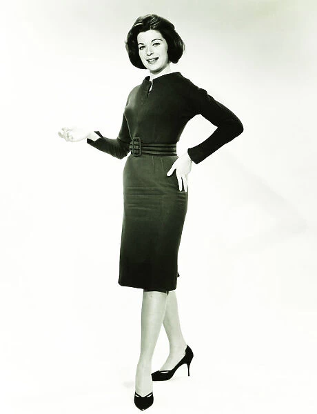 Woman in little black dress posing in studio, (B&W), portrait