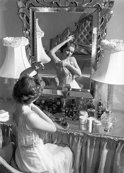 Woman looking in mirror, checking underarms (B&W)