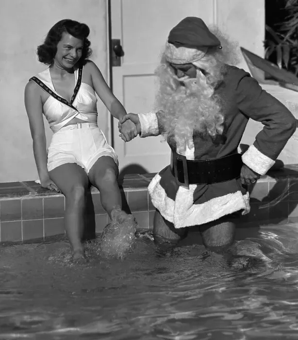 Framed Print : Woman with Man Dressed as Santa Wading in Pool Framed Print : Woman with Man Dressed as Santa Wading in Pool