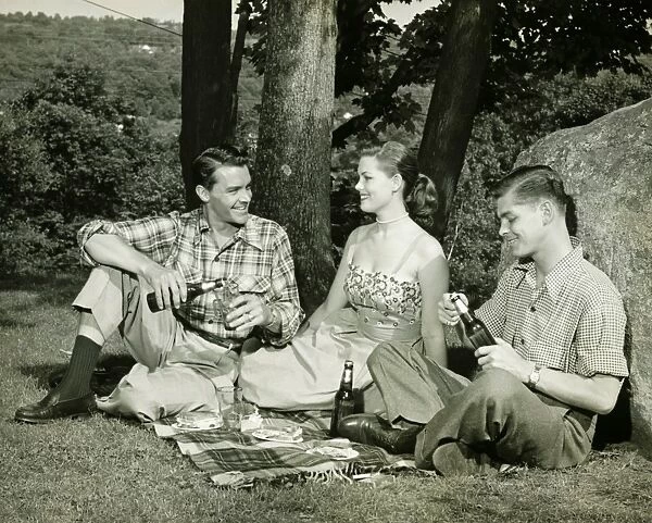 Woman and two men picnicking, (B&W)