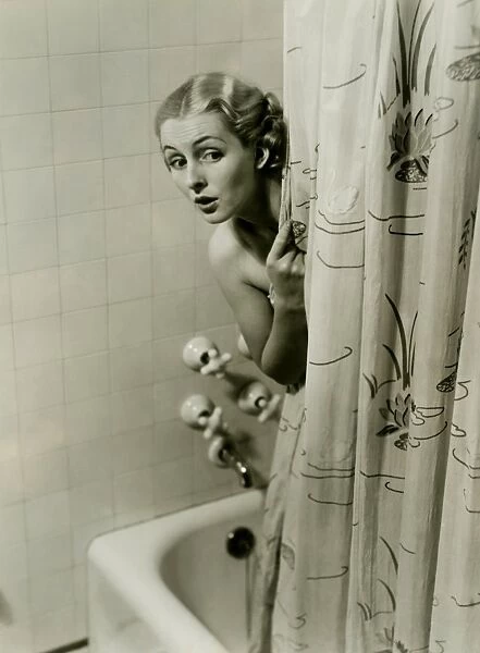 Woman peeking from behind shower curtain