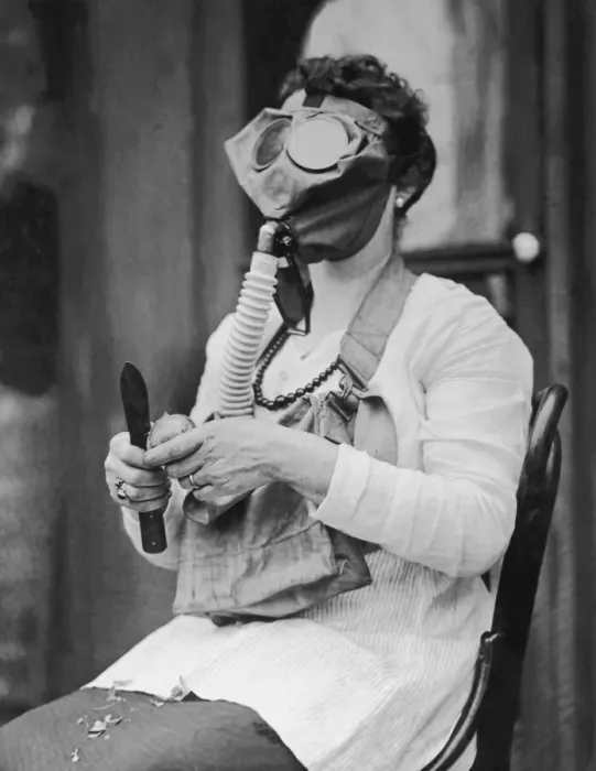 Framed Print : Woman peeling potato, wearing gas mask (B&W) Framed Print : Woman peeling potato, wearing gas mask (B&W)