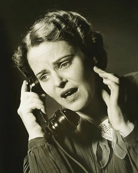 Woman on phone in studio, (B&W), close-up, portrait