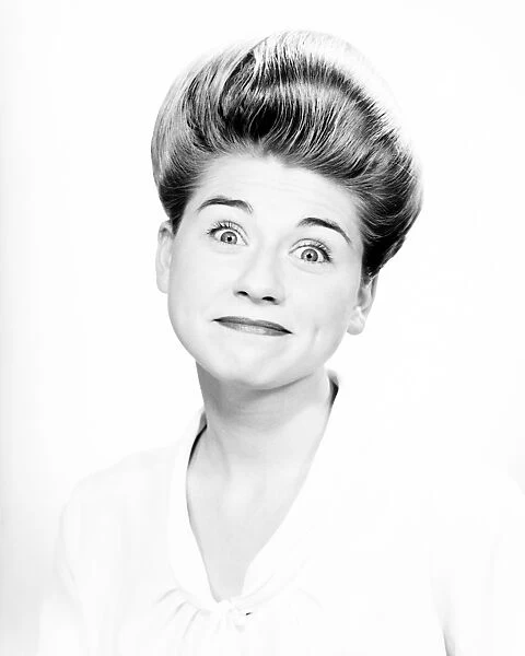 Woman with pompadour making face in studio, (B&W), close-up, portrait