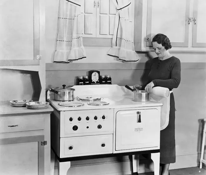 Framed Print : Woman Pouring Milk into Pot in Kitchen Framed Print : Woman Pouring Milk into Pot in Kitchen