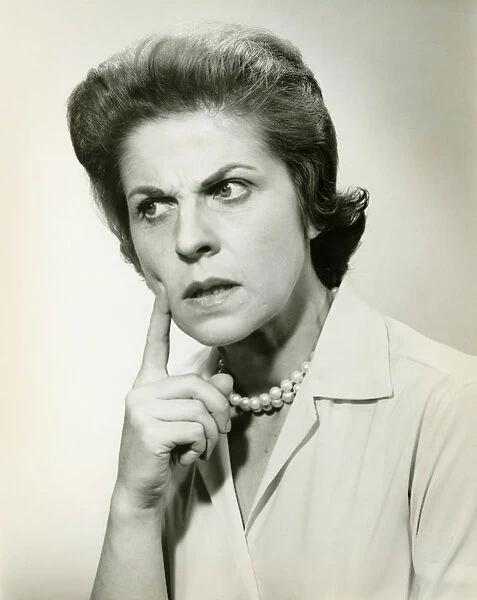 Woman with puzzled expression, in studio, (B&W), portrait