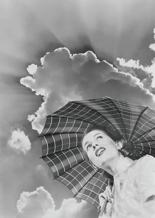 Framed Print : Woman in raincoat holding umbrella looking up into sky of dark clouds and impending storm