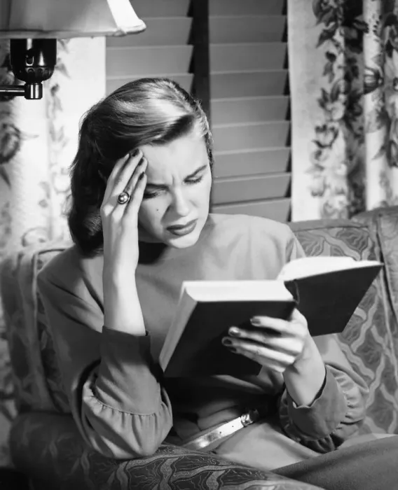 Framed Print : Woman reading book, touching forehead, (B&W) Framed Print : Woman reading book, touching forehead, (B&W)