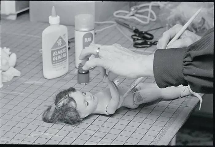 Framed Print : Woman Repairing Doll